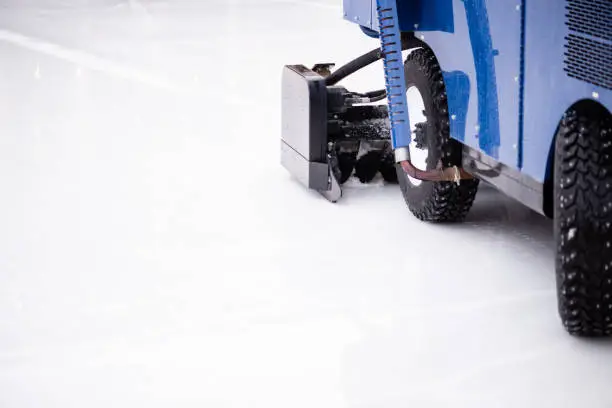 Resurfacing machine cleaning ice of hockey rink. Copy space.