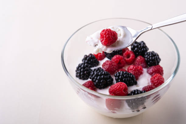 istock Ice cream with raspberry, blackberry berries with spoon in glass bowl on white background 1164694565