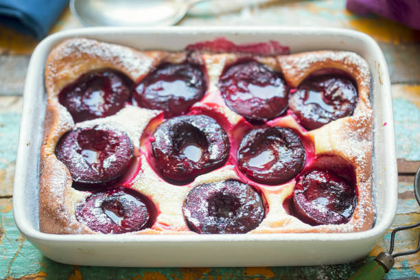 French clafoutis with plums and icing sugar French clafoutis with plums and icing sugar clafoutis stock pictures, royalty-free photos & images