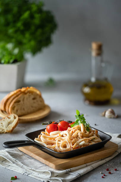 istock Squid rings with tomato and basil on wooden board 1164697951