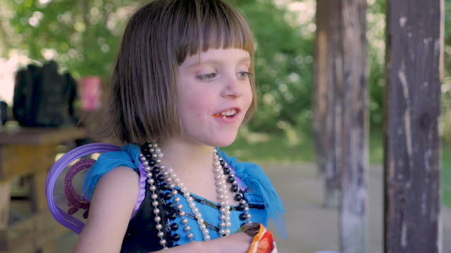 Young 4 - 5 year old girl with big blue eyes eating junk food