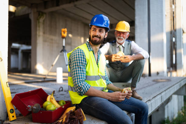 istock Happy mature and young engineer, architect, worker sitting at building site and resting 1164700143
