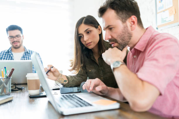 istock Professionals Discussing Over Laptop At Desk 1164700179
