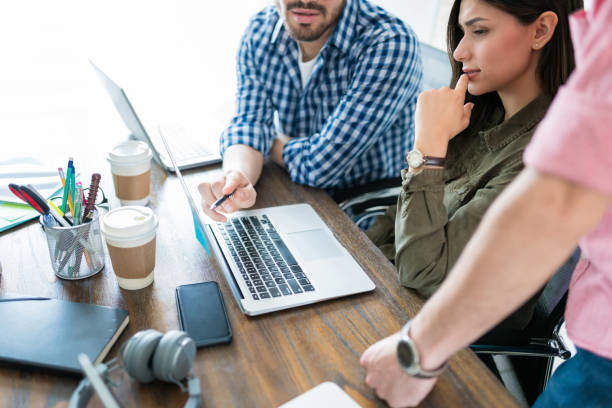 istock Coworkers Examining Data On Laptop At Workplace 1164702043