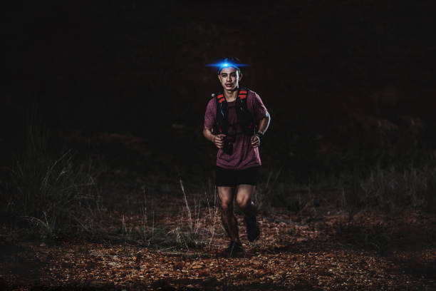 istock trail runner running on the rocky road in the night 1164702787