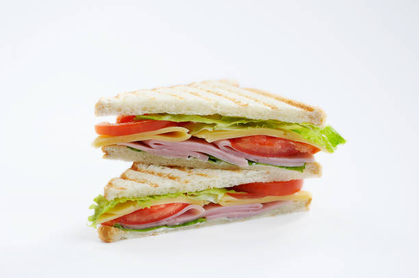 istock White bread sandwich stuffed with ham, cheese, tomato slices and lettuce leaves. 1164702861