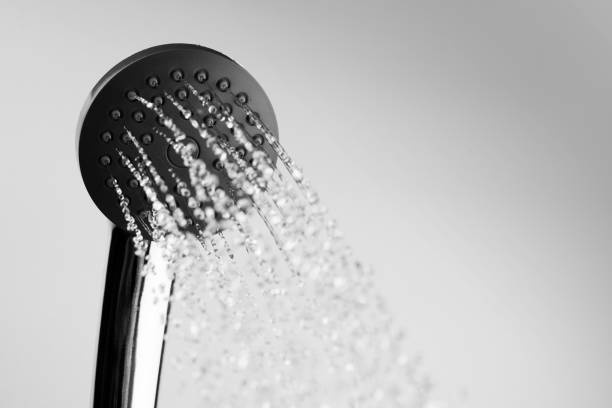 istock Water drops flowing from shower head in bathroom gray background 1164703205