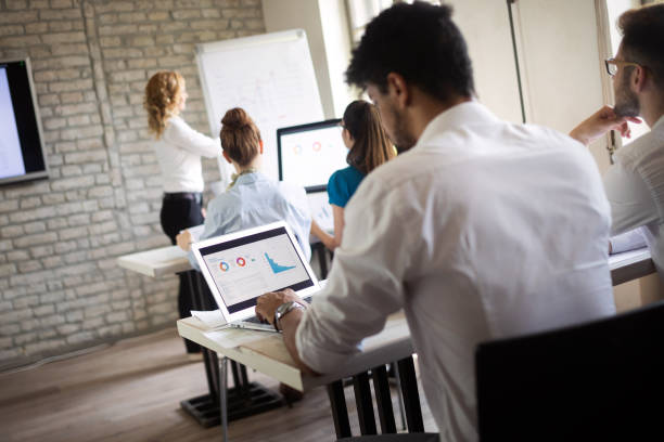istock Successful happy group of people learning software engineering and business during presentation 1164704380