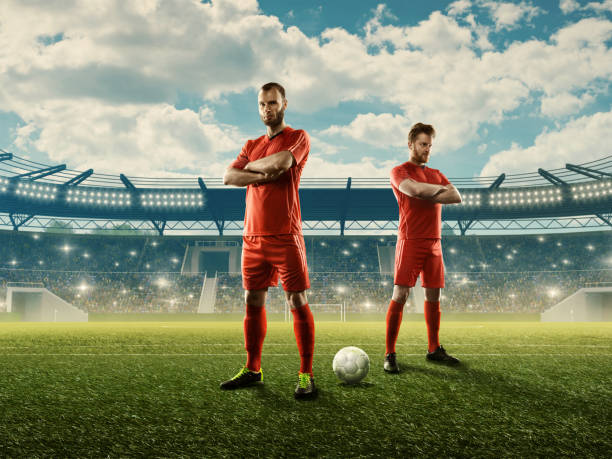 Soccer team in sports uniform on a stadium ready for a game Two soccer players in sports uniform on a field ready for a game. Cloudy blue sky, stadium with spectators. Fans cheering. Sports event. 3D stadium offense sporting position photos stock pictures, royalty-free photos & images