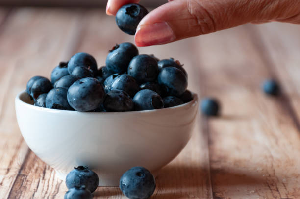 istock Woman eating blueberries 1164704733
