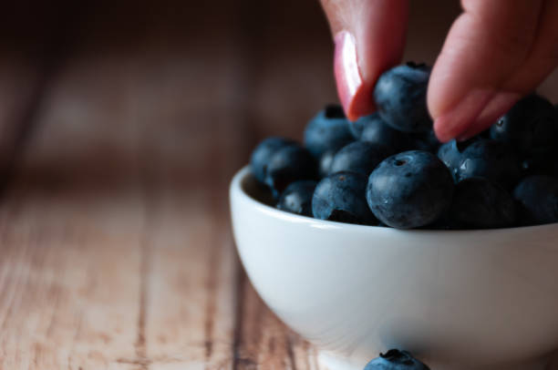 istock Woman eating blueberries 1164704734
