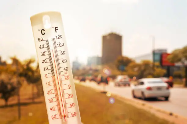 Photo of Thermometer in front of cars and traffic during heatwave