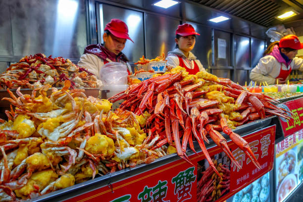 Food vendors offers its products at the Donghuamen Night Market near Wangfujing Street in Beijing, China BEIJING, CHINA - MARCH 11, 2016: Food vendors offers its products at the Donghuamen Night Market near Wangfujing Street in Beijing, China wangfujing stock pictures, royalty-free photos & images