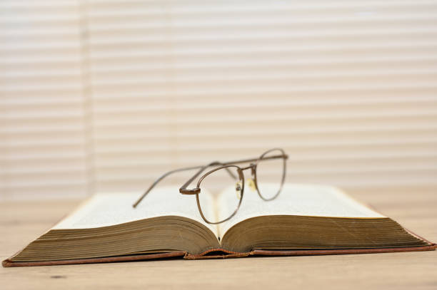 istock Old brown books open on a wooden table 1164709948