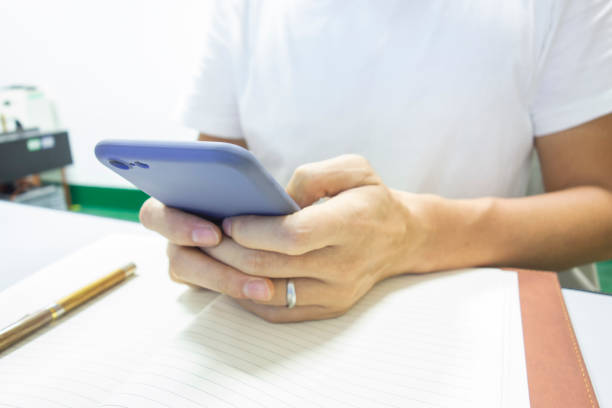 istock Hands on a notebook and mobile phones in operation 1164710123