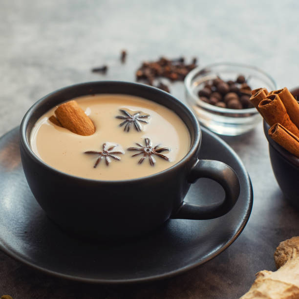 istock Masala tea. Traditional indian chai in black cup with spiced on grey background 1164710513