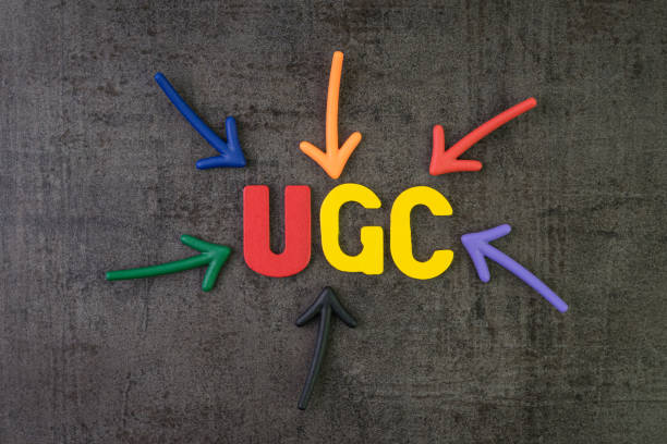 ugc、ブランドコミュニケーションオンライン広告コンセプトでユーザー生成コンテンツ、黒いセメント黒板壁の中心にugcという言葉を指すマルチカラー矢印 - buzzword ストックフォトと画像
