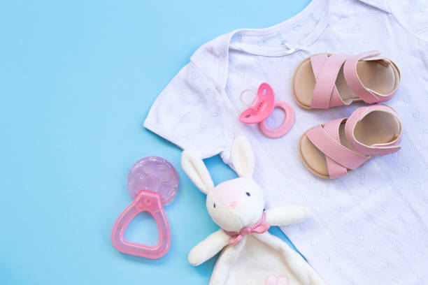 istock Baby clothes, shoes, teether and pacifier on a blue background 1164717449