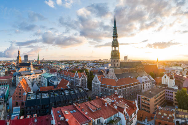 Historical buildings surrounding the St. Peters church in Old Town Riga at sunrise