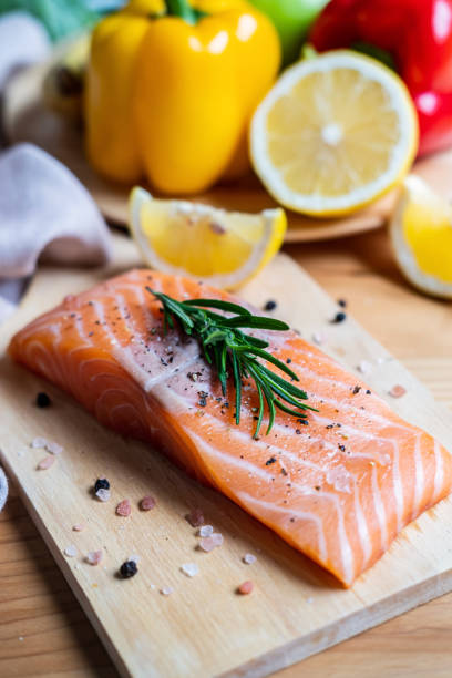 istock Fresh salmon steak with herbs, lemon and ingredients for cooking in kitchen 1164729212
