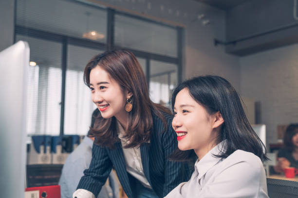 istock Two young women having a discussion in a business 1164729426
