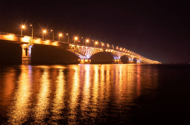 istock Summer Night over Volga river, golden light bridge between Saratov Engels cities, Russia 1164730663