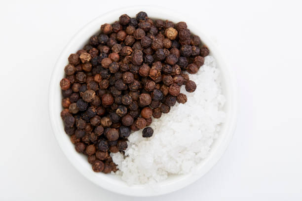 istock Bowl of black pepper with salt isolated on white background, 1164731378
