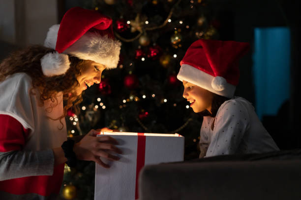 istock Happy mother opening a Christmas present from her daughter 1164731584