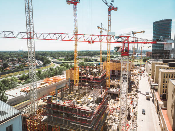 istock Industrial cranes working high above the busy construction site 1164732402