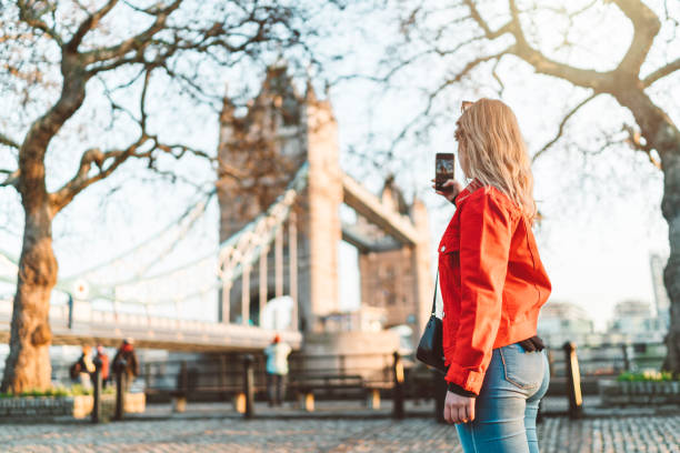 glücklicher reisender sightseeing london, ein foto von tower bridge - pay phone telephone people women stock-fotos und bilder