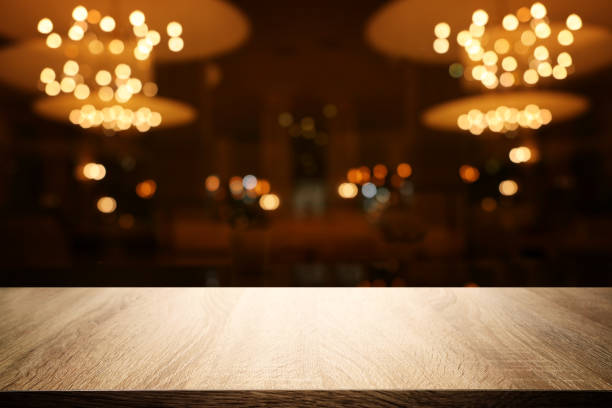 istock Image of wooden table in front of abstract blurred restaurant lights background 1164738457