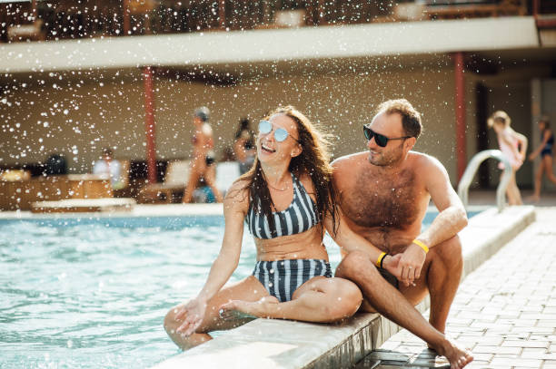 istock beautiful couple having fun by the pool 1164744719