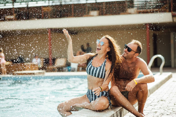 istock beautiful couple having fun by the pool 1164744740