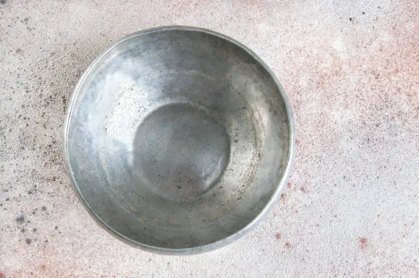 Vintage pewter bowl on a concrete background. Copy space for text.