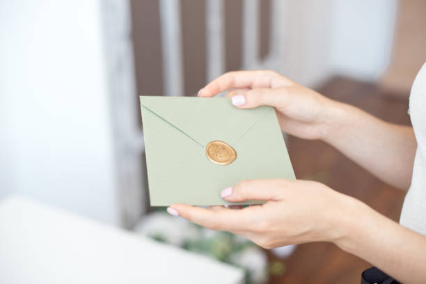 close-up photo of female hands holding invitation envelope with a wax seal, a gift certificate, a postcard, wedding invitation card. - opening mail letter envelope imagens e fotografias de stock