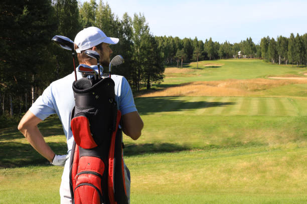 istock Golf player walking and carrying bag on course during summer game golfing. 1164749747