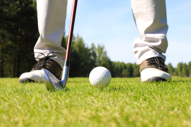 istock Golf player at the putting green hitting ball into a hole. 1164749919