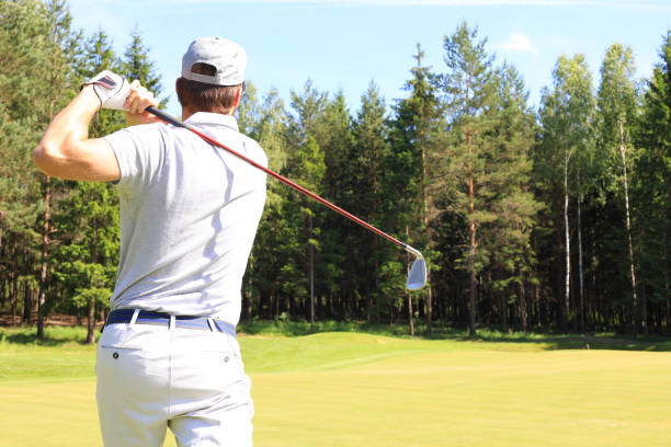 istock Golf approach shot with iron from fairway at sunny day. 1164749948