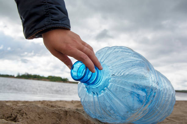 istock A man is cleaning up garbage and plastic bottles on dirty beach by collecting them. Environmental pollution 1164756674