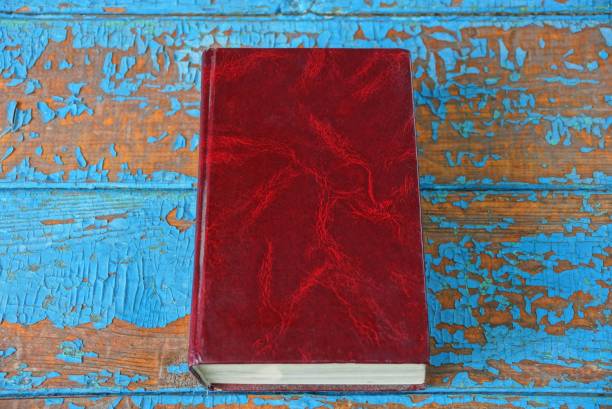 istock closed book with a red cover is lying on a blue brown worn table 1164756910