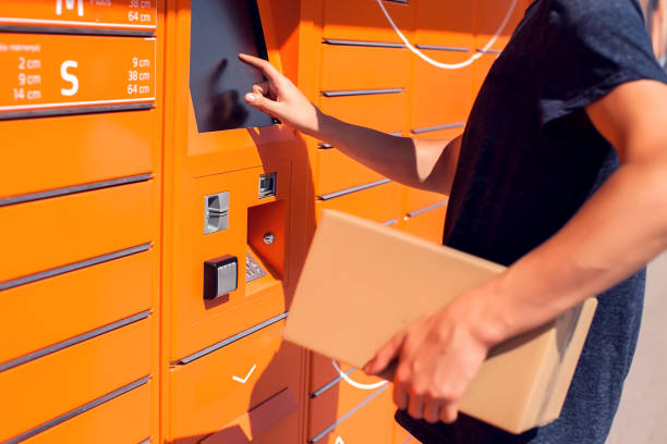 Man client using automated self service post terminal machine or locker to deposit the parcel for storage