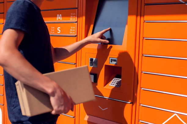 istock Man client using automated self service post terminal machine or locker to deposit the parcel for storage 1164758877