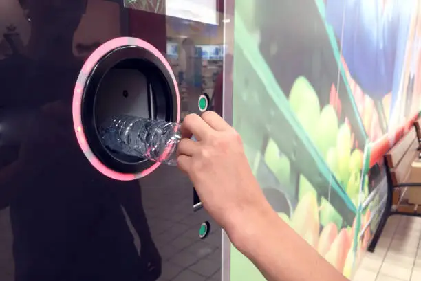 Shoppers return their bottles and cans of reusable packagings in a reverse vending machine