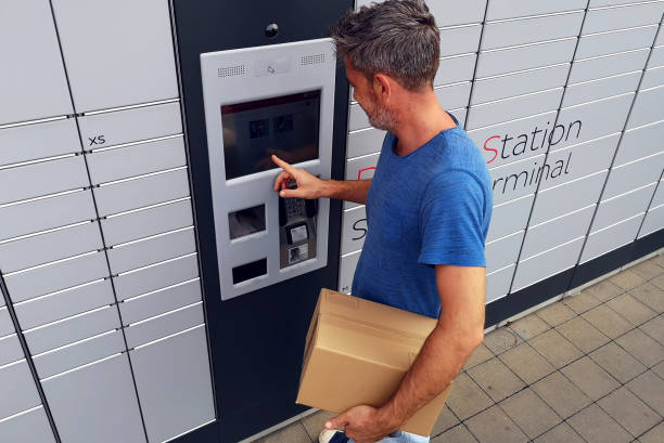 istock Client using automated self service post terminal machine or locker to deposit a parcel for storage 1164761865
