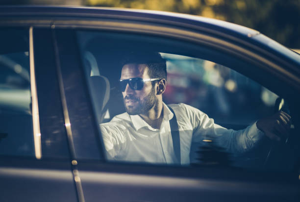 istock Young businessman driving a car in reverse. 1164763249