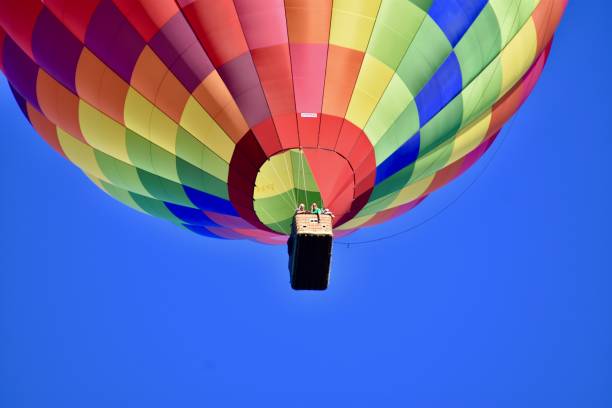 un ballon coloré naviguant dans le ciel bleu - hot air balloon flying heat people photos et images de collection