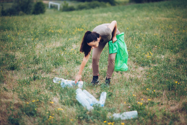 istock Woman Picking Up Trash in Rural Scene 1164766566