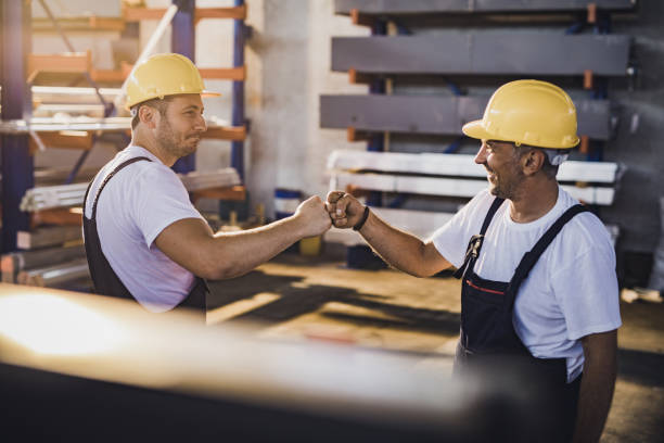 istock Happy manual workers fist bumping in aluminum mill. 1164766646