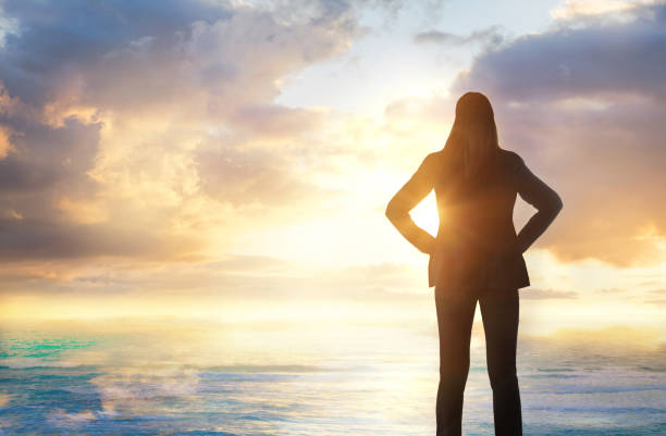 Young woman looking over the sunset. Future, freedom, success and stability concept Young woman looking over the sunset. Future, freedom, success and stability concept environment computer cloud leadership stock pictures, royalty-free photos & images