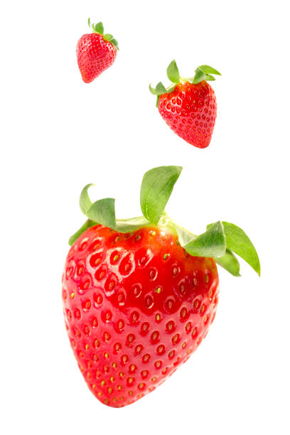 istock Photograph of fresh strawberries falling isolated on white background 1164769238